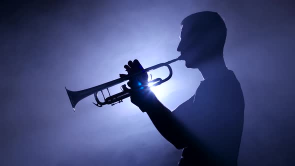 Professional Musician in Smoky Studio Playing on Trombone, Silhouette. Close-up