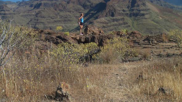 Crane Shot of Woman Stretching in Mountains