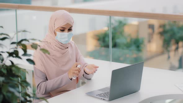 Young Muslim Woman in Protective Medical Mask Processes Hands Antiseptic Islamic Girl Manager