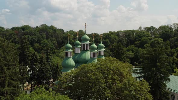 Nice top view of the church. Green domes among the trees. Monastery in the forest.