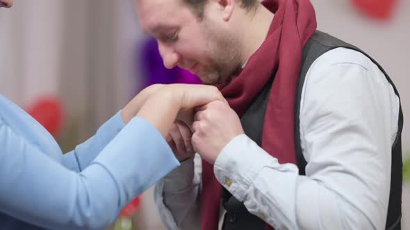 Closeup Side View of Loving Husband Boyfriend Kissing Hand of Unrecognizable Wife Girlfriend Smiling