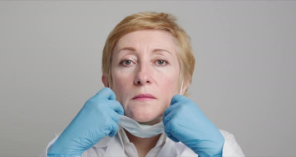 Adult Female Doctor Puts on a Medical Mask