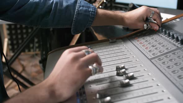 Hands of Sound Engineer Using Soundboard