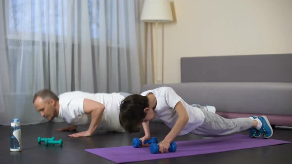 Sportive Father Teaching His Son Doing Push-Ups, Military Training, Endurance