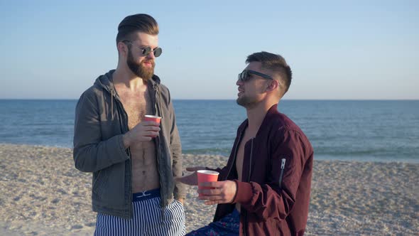 Male Gossip, Cheerful Friends in Glasses Are Drinking Tea and Talking on Beach