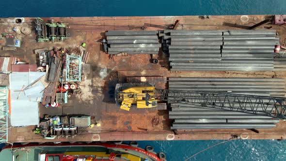 Ascening aerial top down of metal pipes on ferry ship during sunny day in Asia.