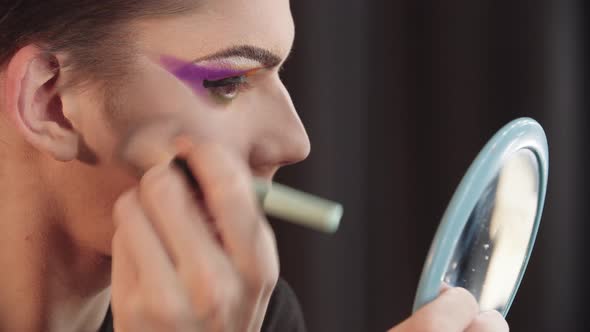 Drag Artist  Young Man Removing Baking Powder From His Under Eyes Using a Brush