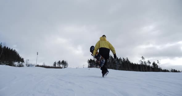 The Camera Captures the Snowboarder Climbing the Mountain