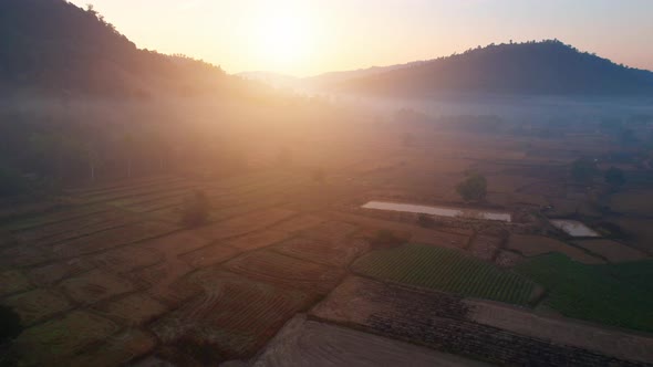 Aerial view from a drone over misty landscape on farmland. 4K