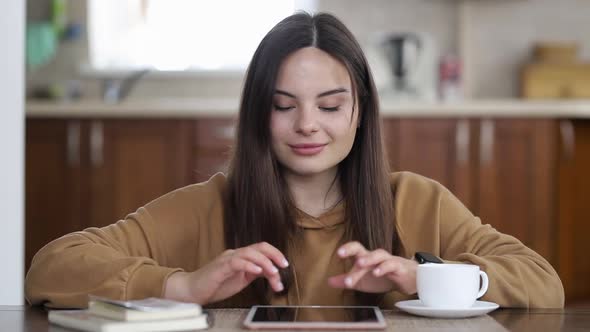 Beautiful young girl is chatting on her tablet