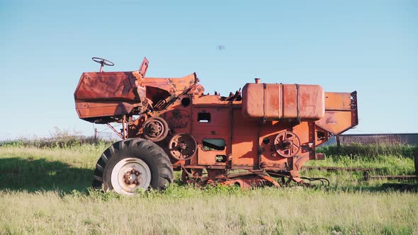 Old rusted tractor aged on farm land. Abandoned agricultural machinery