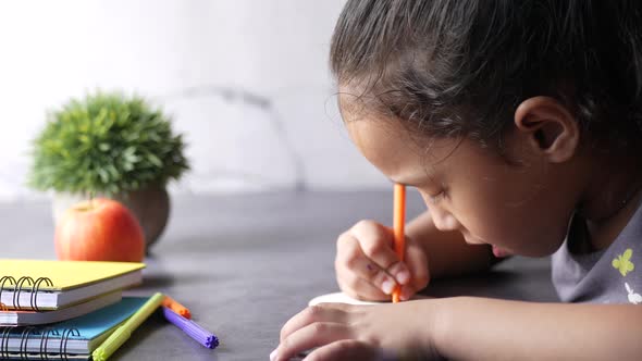 Child Girl Drawing on Paper on Table Sice View