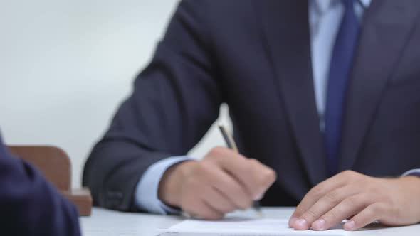 Businessman Signing Agreement and Shaking Partners Hand, Profitable Cooperation