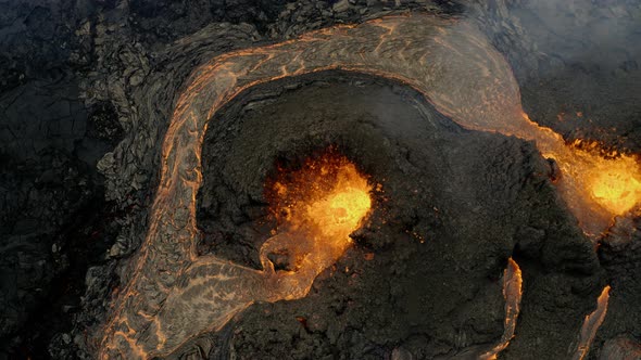 Aerial view above a erupting lava basin and boiling crater - overhead, drone shot