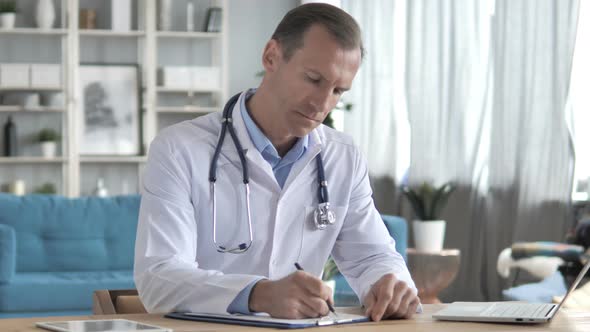 Senior Doctor Writing Medical Documents, Prescription for Patient