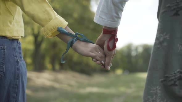 Unrecognizable Man Woman Ribbons Wrists Standing Outdoors