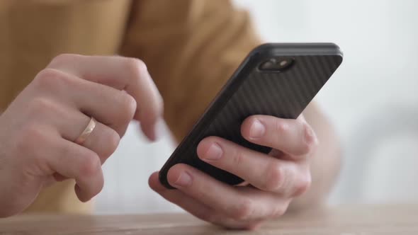 Hands Close up of Young Man using Smartphone