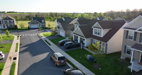 Lifestyle homes in USA. Modern suburban view in countryside. Rural field by new houses.