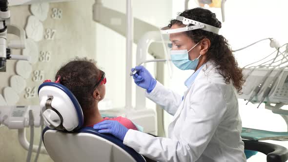 Female Dentist Treating Bad Tooth of Girl Patient