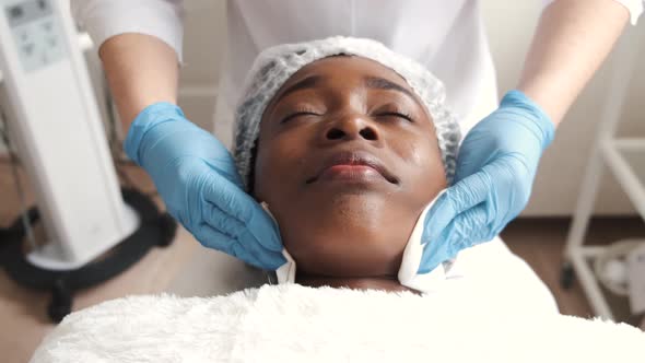 Cosmetologist Doing Facial Massage Manually to African Client