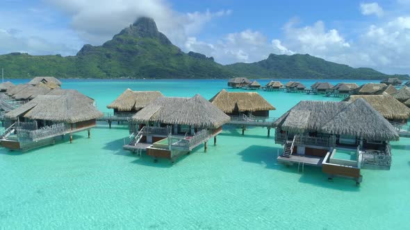 Aerial drone view of a luxury resort and overwater bungalows in Bora Bora tropical island.