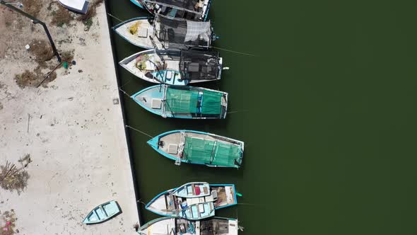 Aerial view looking straight down and camera showing small wooden fishing boats in a harbor in Mexic