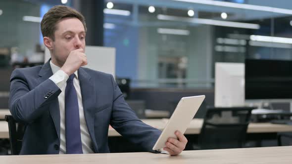 Businessman Reacting to Loss on Tablet in Office Sitting