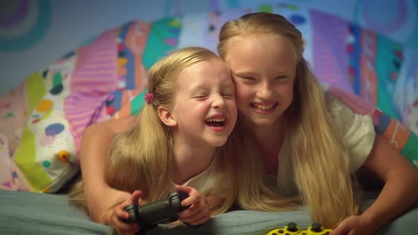 Joyful Blonde Kids Playing Video Game with Joystick