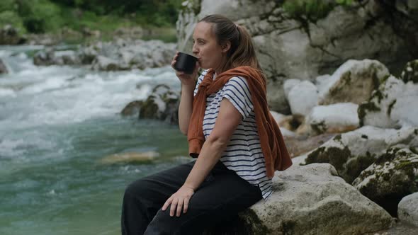 Travel Woman drinks mocha coffee and looking at mountain river, road trip and staycation concept.