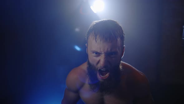 Sweaty Free Fighter Looks at Camera and Screaming in the Smoky Boxing Gym After Hard Training