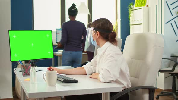 Manager with Face Mask Typing on Computer with Green Screen