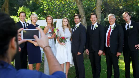 Photographer taking photo of bride and groom with there family 4K 4k