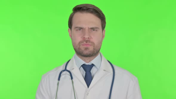 Young Doctor in Denial on Green Background