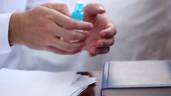 A Man Disinfects His Hands With An Aerosol Product At Work In The Office During A Virus