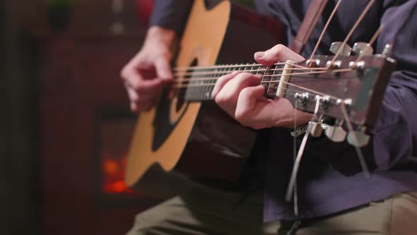 Man's Hands Holding an Acoustic Guitar and Performing a Composition