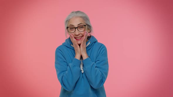 Excited Amazed Elderly Woman Raising Hands in Surprise Looking at Camera Shocked By Sudden Victory