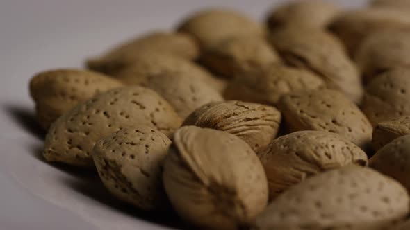 Cinematic, rotating shot of almonds on a white surface - ALMONDS