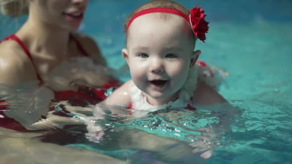 Baby Teaching to Swim in the Swimming Pool