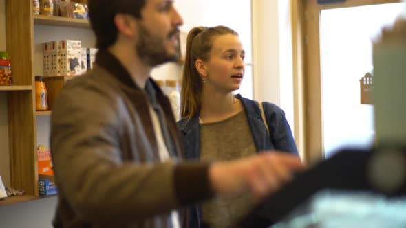 Couple looking at display case in delicatessen