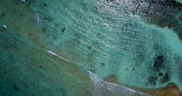 Daytime flying abstract view of a paradise sunny white sand beach and aqua blue water background in 