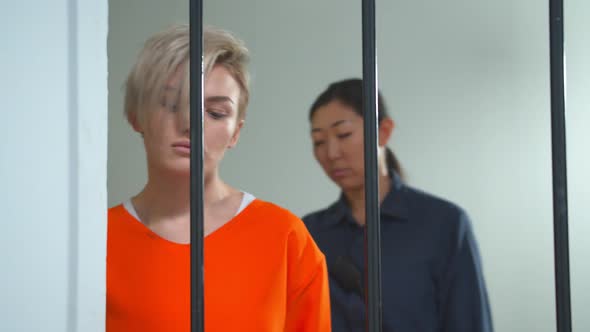 Female Jailer Leads a Criminal in Her Cell