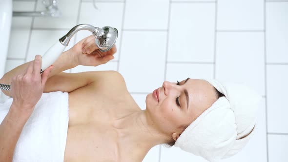 Young Woman in Bathroom Talking By Watering Can