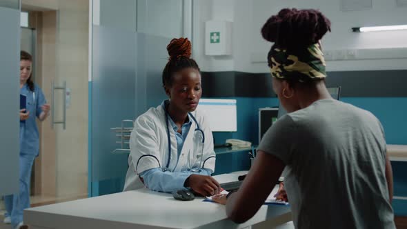 Young Patient Signing Consultation Papers for Healthcare System