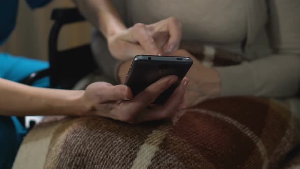 Nurse Helping Old Woman Use Mobile Phone, Easy App for Senior People, Technology