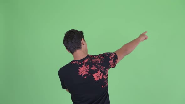 Rear View of Young Man Pointing Finger