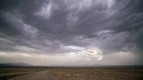 Timelapse of dark storm clouds moving over desert landscape