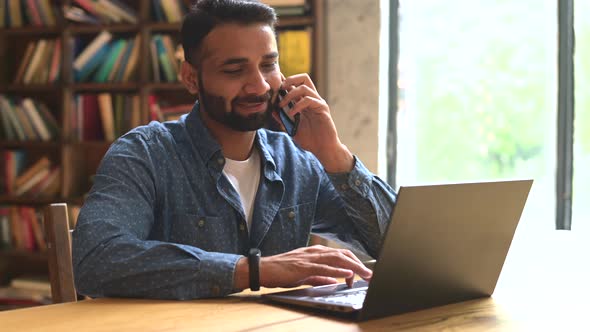 Mid Adult Indian Man Working in His Home Office Using Smartphone