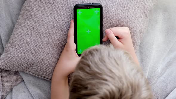 Boy Holding His Smartphone with Green Screen Scrolling Touching Screen