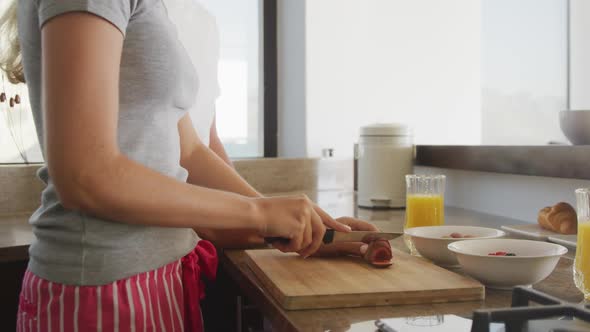 Caucasian couple cutting vegetables in the kitchen during coronavirus covid19 pandemic