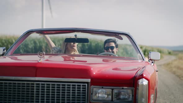 Front view video of happy young couple in a cabriolet. Shot with RED helium camera in 8K